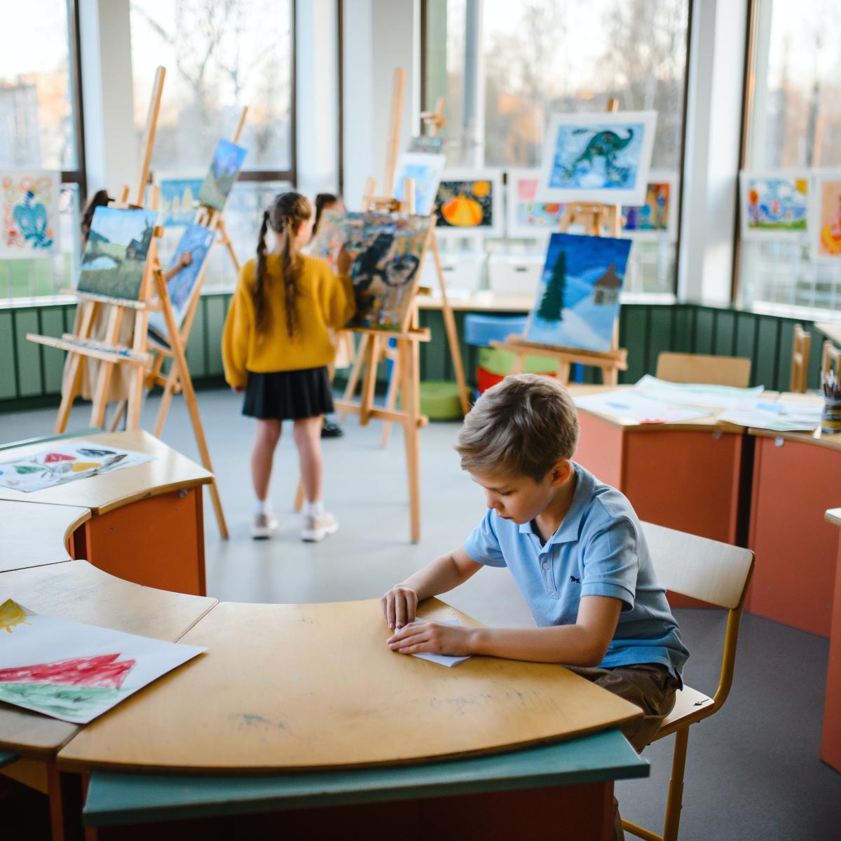 Kid working on art project in classroom